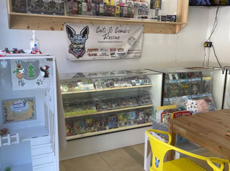 A store interior featuring shelves filled with various items, including toys and comic books, in a room designated for cat rescue.